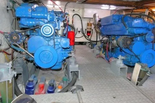 Slide: The Image of Engine room of 1983 CHB Sedan Trawler with dual blue marine engines. - 21