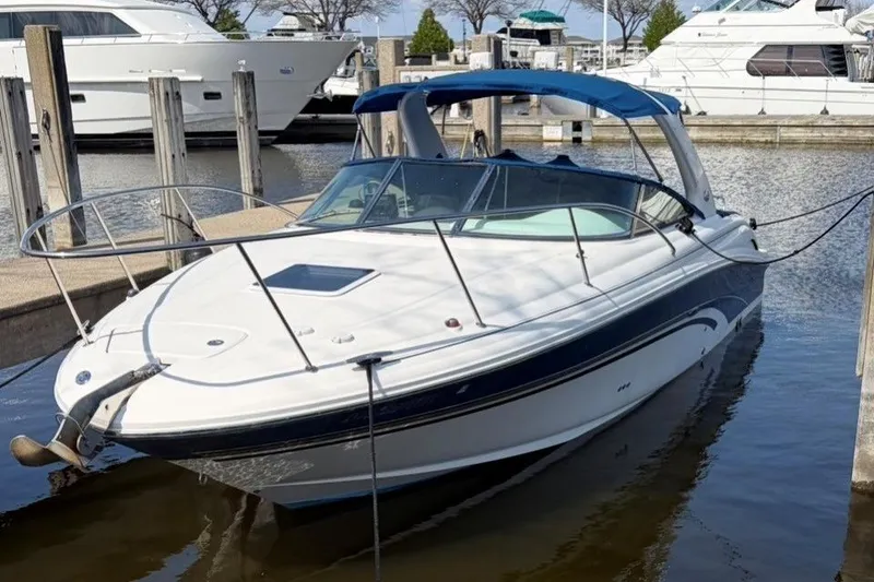 Slide: The Image of 2001 Sea Ray 290 Sun Sport boat docked at marina, featuring sleek design and blue canopy. - 1