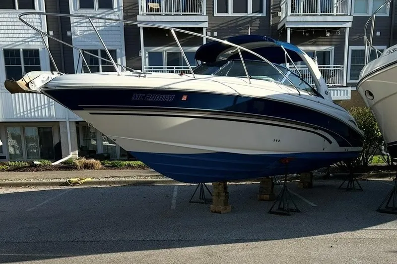 Slide: The Image of 2001 Sea Ray 290 Sun Sport boat on stands, parked near residential buildings. - 6