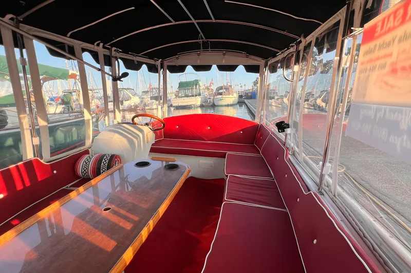 Slide: The Image of Interior of a 2007 Duffy 16 boat with red seating and wooden table. - 7