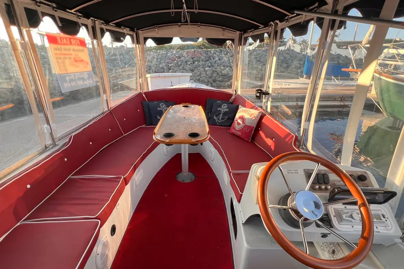 Slide: The Image of Interior of a 2007 Duffy 16 boat with red seating and wooden steering wheel. - 8