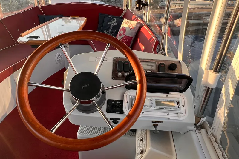 Slide: The Image of Interior of a 2007 Duffy 16 boat with wooden steering wheel and red seating. - 9