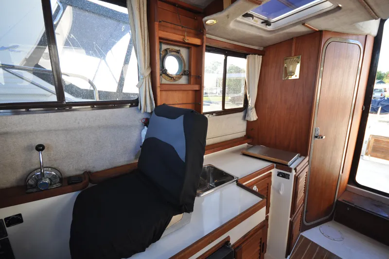 Slide: The Image of Interior of a 2007 Ranger Tug R-25 boat with wooden cabinetry and seating. - 13