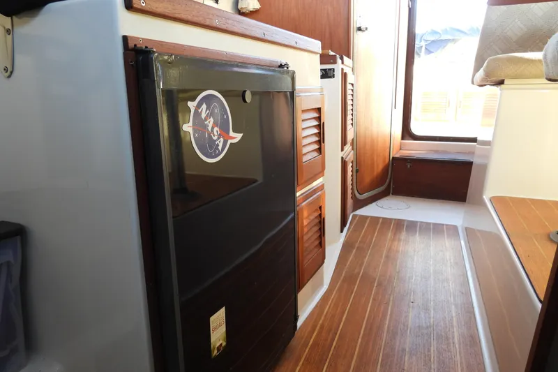 Slide: The Image of Interior of a 2007 Ranger Tug R-25 boat with wood flooring and cabinetry. - 15
