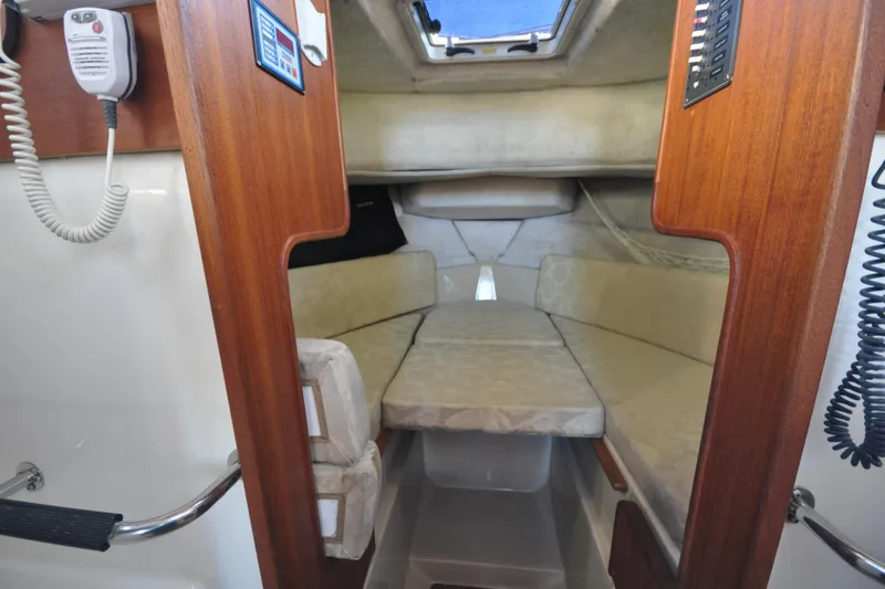 Slide: The Image of 2007 Ranger Tug R-25 cabin interior with cozy seating and wooden accents. - 21