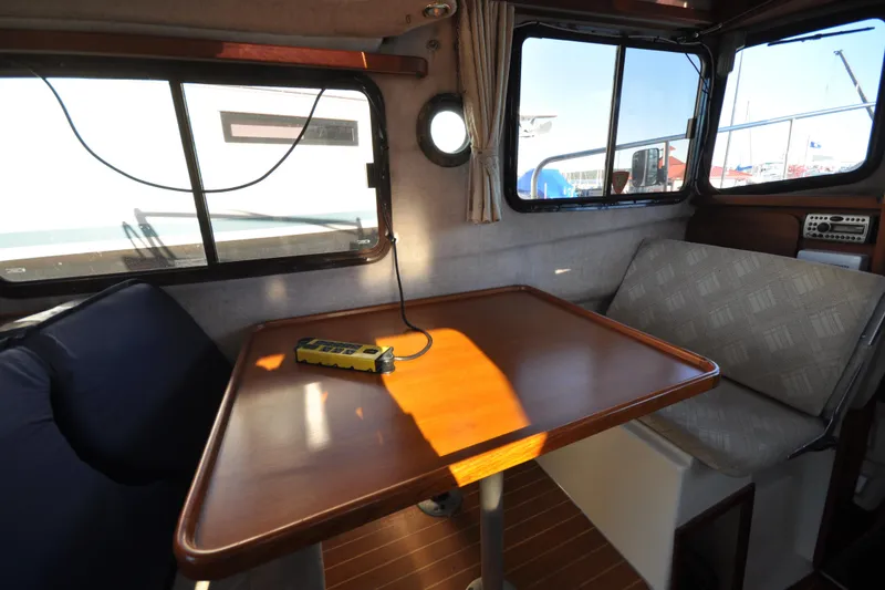 Slide: The Image of Interior of 2007 Ranger Tug R-25 with wooden table and cushioned seating. - 24