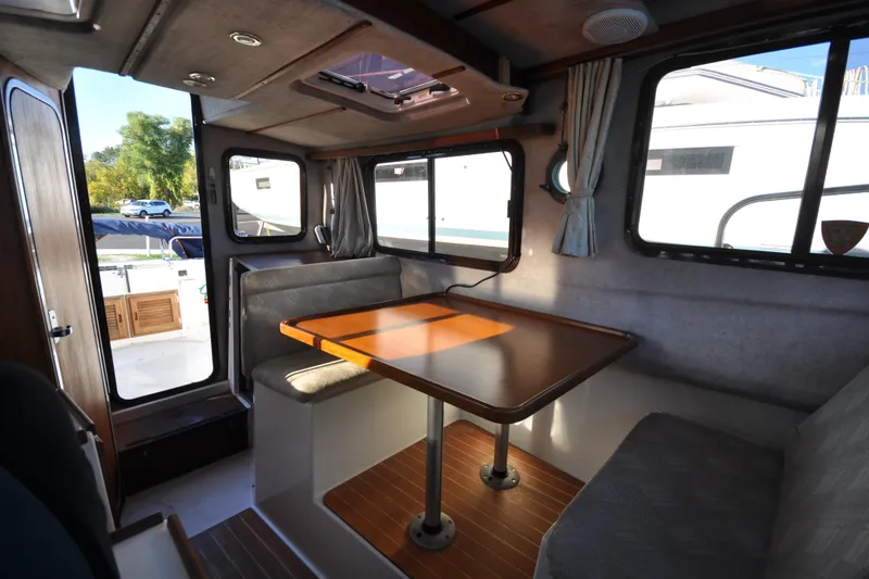 Slide: The Image of Cozy interior of 2007 Ranger Tug R-25 with dining area and windows. - 26