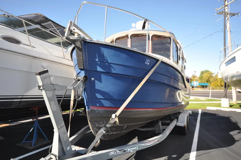 Slide: The Image of 2007 Ranger Tug R-25 boat on trailer in a parking lot. - 3