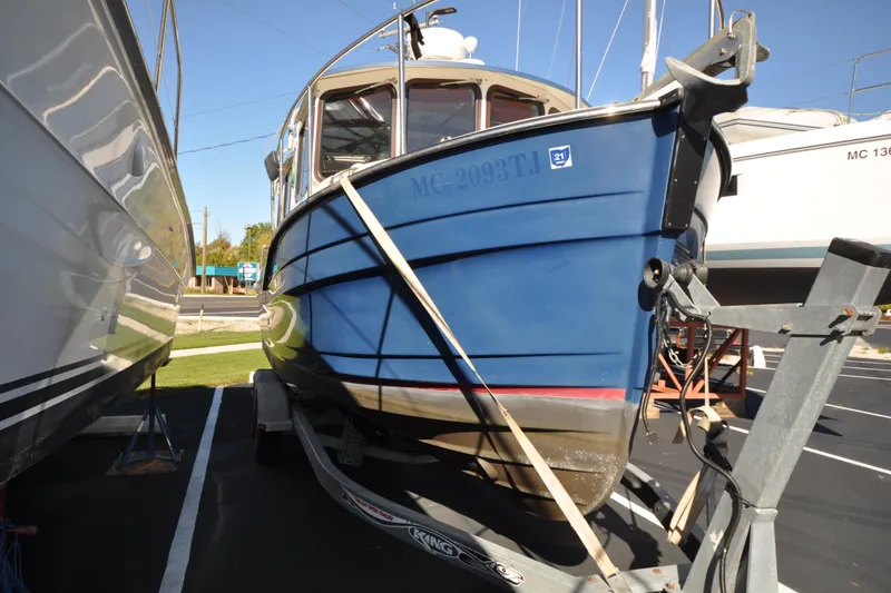 Slide: The Image of 2007 Ranger Tug R-25 boat on trailer, blue hull, parked outdoors. - 4
