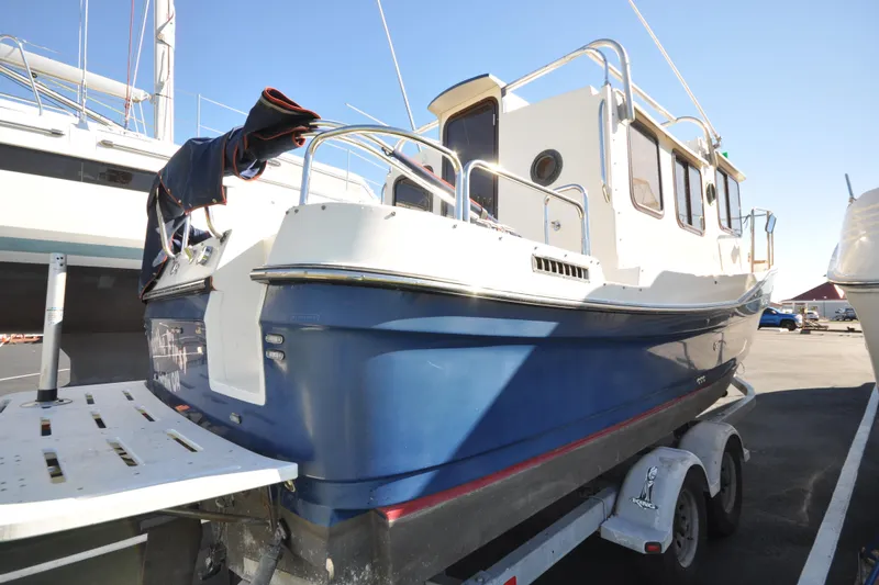 Slide: The Image of 2007 Ranger Tug R-25 boat on trailer, blue hull, docked in marina. - 7