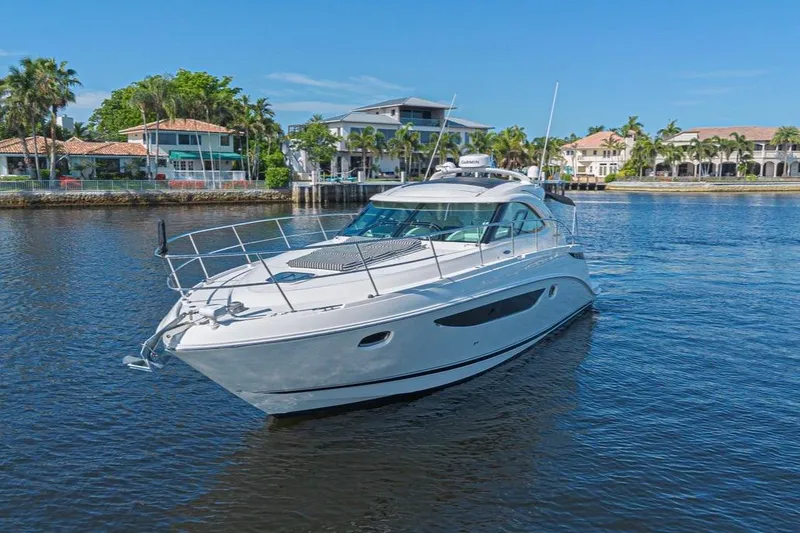 The Image of 2014 Sea Ray 410 Sundancer yacht cruising on a sunny waterfront. - 0