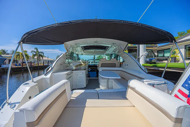 Slide: The Image of 2014 Sea Ray 410 Sundancer yacht interior with seating, table, and canopy. - 11