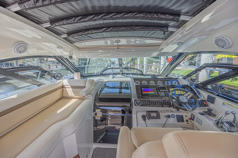 Slide: The Image of Interior view of 2014 Sea Ray 410 Sundancer yacht cockpit with modern controls and seating. - 15