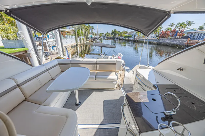 Slide: The Image of Luxurious 2014 Sea Ray 410 Sundancer yacht interior with seating and table, docked by a canal. - 16