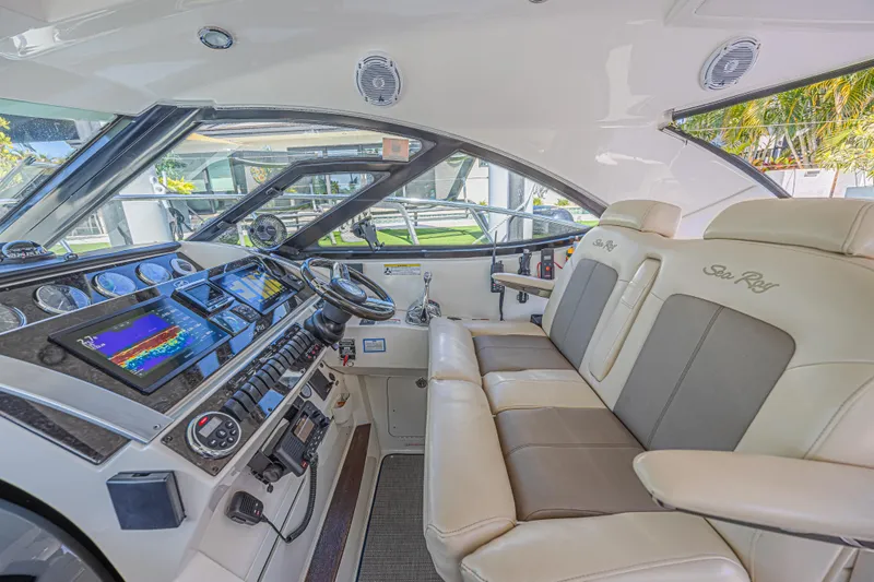 Slide: The Image of 2014 Sea Ray 410 Sundancer helm with modern controls and plush seating. - 19