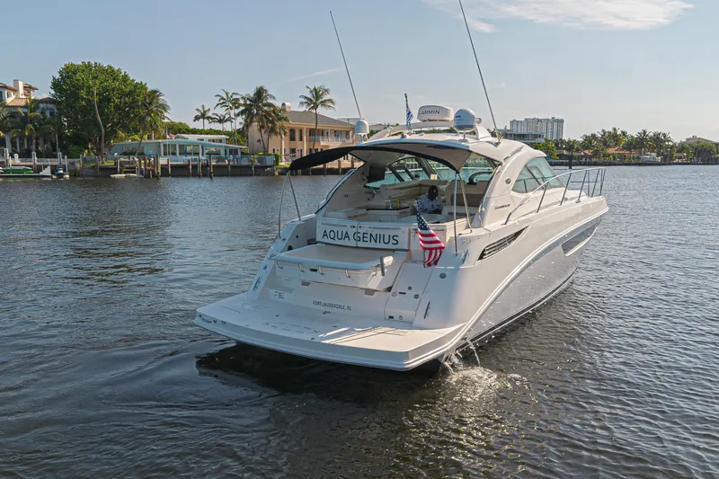 Slide: The Image of 2014 Sea Ray 410 Sundancer yacht on water, rear view with American flag. - 2