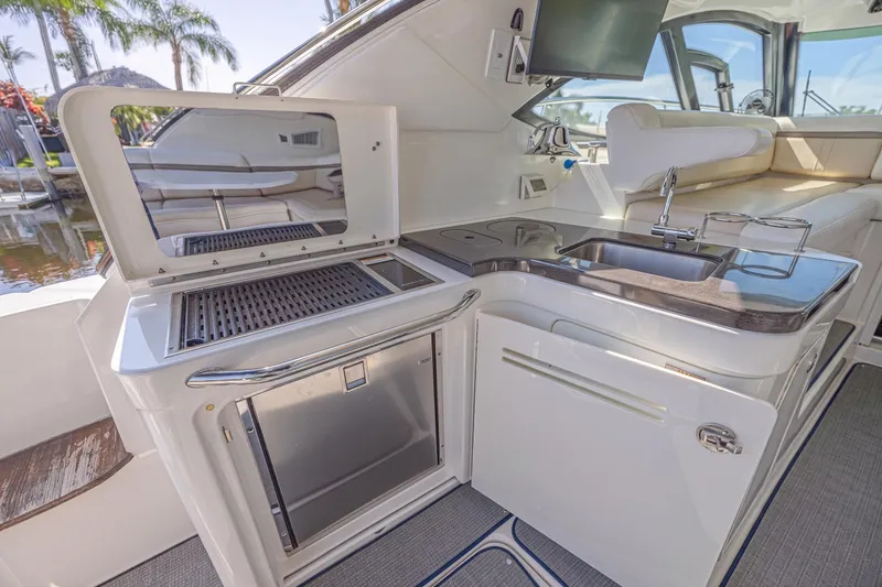 Slide: The Image of Luxurious 2014 Sea Ray 410 Sundancer yacht interior with kitchenette and seating area. - 21