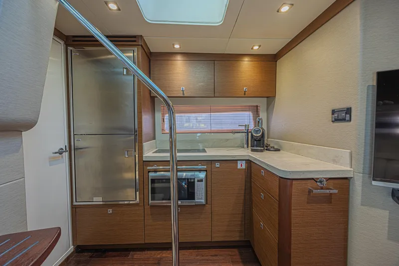 Slide: The Image of Luxurious 2014 Sea Ray 410 Sundancer yacht kitchen with modern appliances and sleek wood cabinetry. - 26