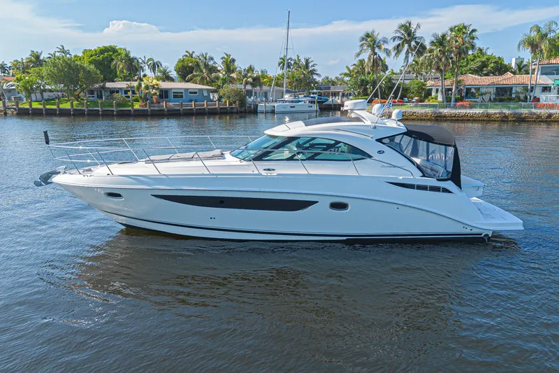 Slide: The Image of 2014 Sea Ray 410 Sundancer yacht cruising on a sunny day near waterfront homes. - 5