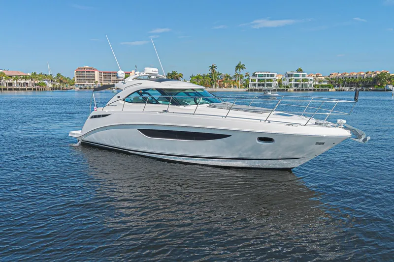 Slide: The Image of 2014 Sea Ray 410 Sundancer yacht cruising on a sunny day in a coastal area. - 6