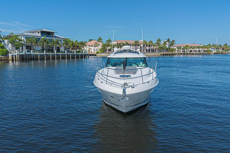 Slide: The Image of 2014 Sea Ray 410 Sundancer yacht on calm water near luxury waterfront homes. - 7