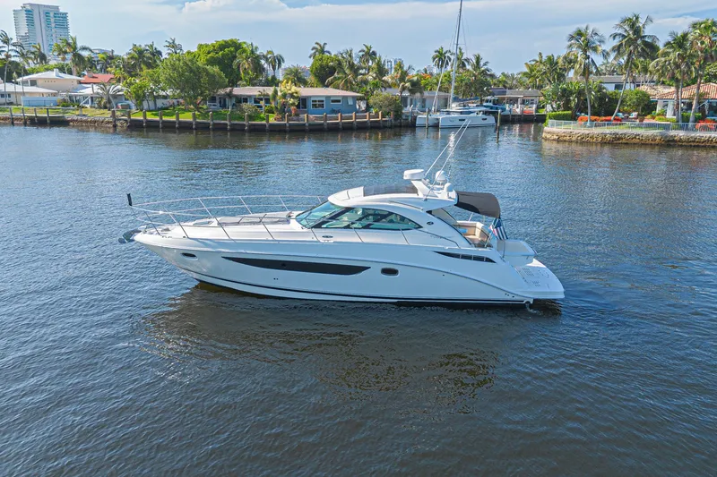 Slide: The Image of 2014 Sea Ray 410 Sundancer yacht cruising on a calm waterway. - 8