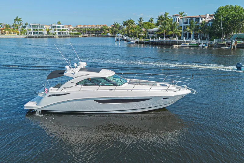 Slide: The Image of 2014 Sea Ray 410 Sundancer yacht cruising on a scenic waterfront. - 9