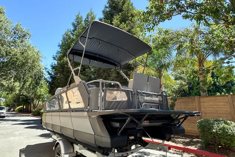 Slide: The Image of 2026 Sea-Doo Switch Fish 21 pontoon boat with canopy, parked on a sunny day. - 24