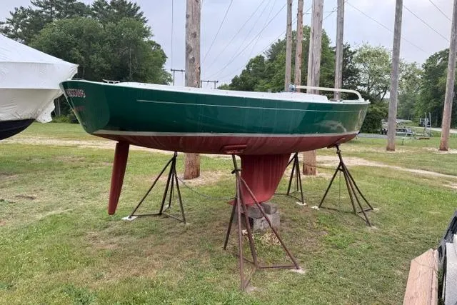 Slide: The Image of Alerion Express 20 sailboat from 1998 on stands, green hull, outdoors. - 5