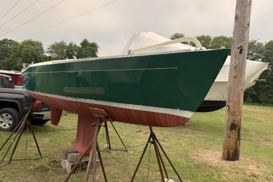 Slide: The Image of Alerion Express 20 sailboat from 1998 on stands, green hull, outdoors. - 2