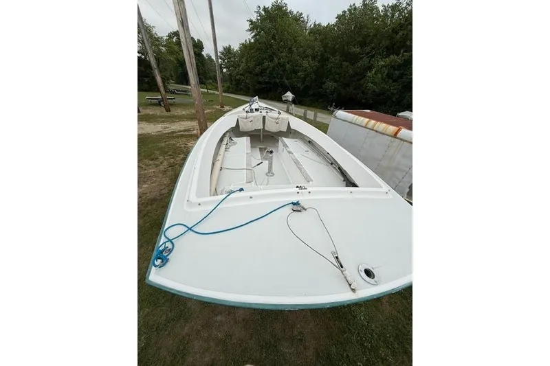 Slide: The Image of 1998 Alerion Express 20 sailboat on grass, surrounded by trees and utility poles. - 9