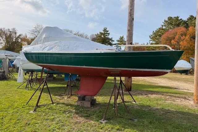 Slide: The Image of Alerion Express 20 sailboat from 1998 on stands, green hull, outdoor storage. - 1