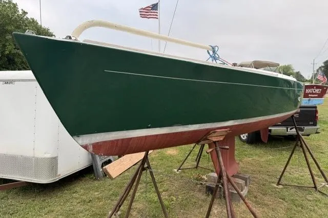Slide: The Image of 1998 Alerion Express 20 sailboat on stands, green hull, American flag in background. - 3