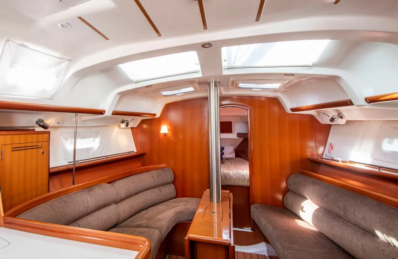 Slide: The Image of Interior of a Beneteau 343 yacht with wood paneling and cushioned seating areas. - 11