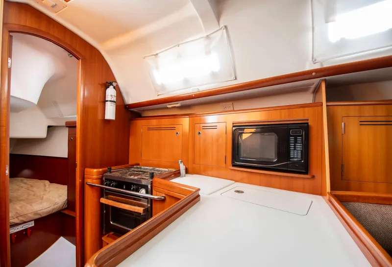 Slide: The Image of Interior of a Beneteau 343 yacht featuring a kitchen and sleeping area. - 14