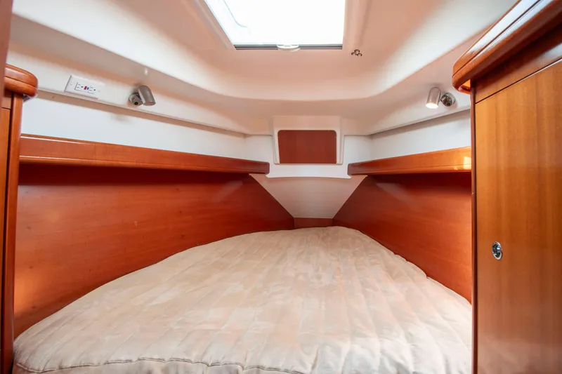 Slide: The Image of Interior of a Beneteau 343 with a cozy bed and wooden paneling. - 19