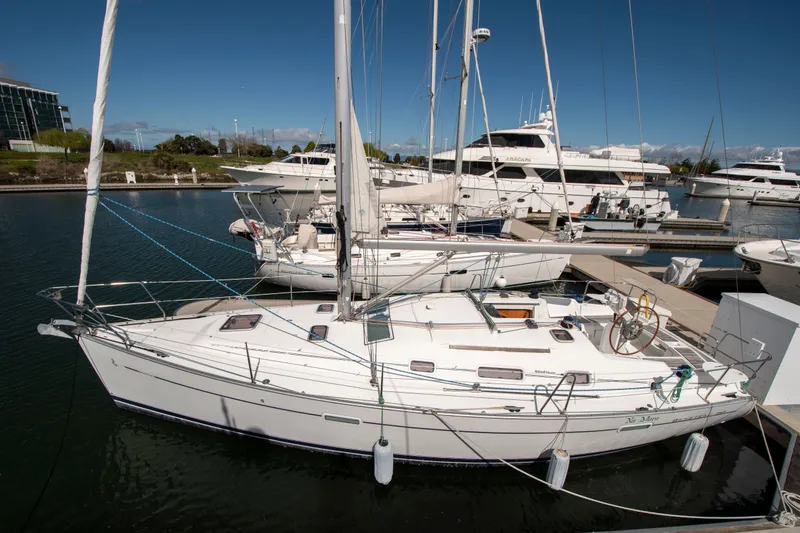 Slide: The Image of A Beneteau 343 sailboat docked in a marina, surrounded by other boats. - 2