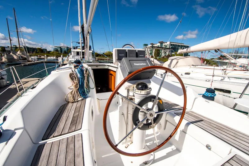 Slide: The Image of The cockpit of a 2006 Beneteau 343 with a wooden steering wheel and ropes. - 4