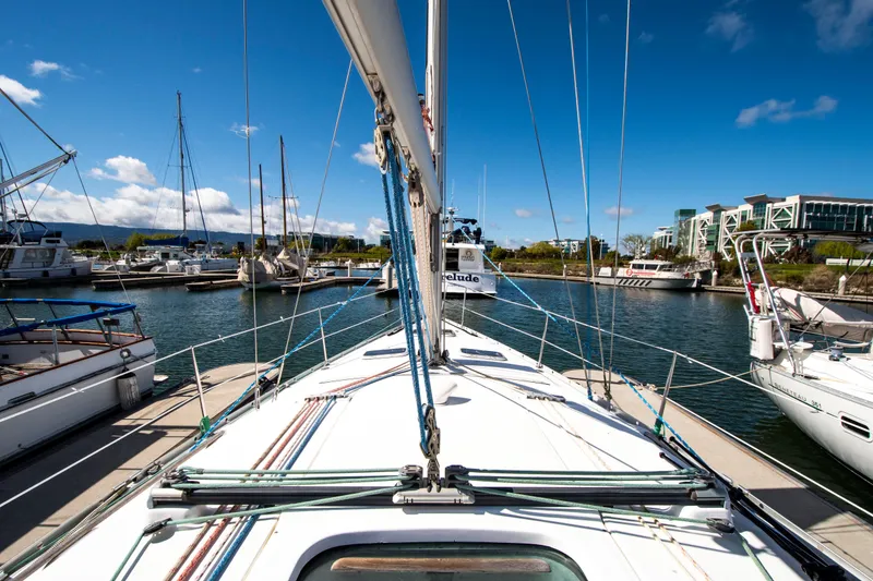 Slide: The Image of Sailboat docked in a marina with a blue sky and other boats in the background. - 9