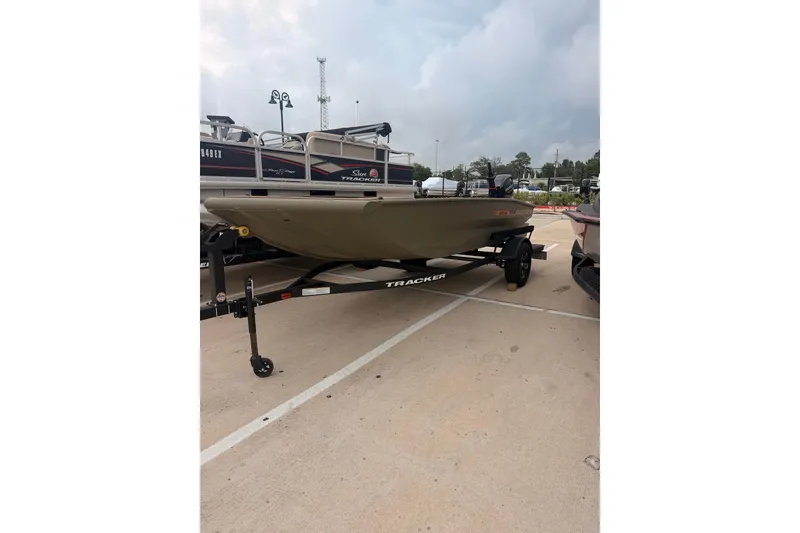 Slide: The Image of A Tracker Grizzly 1756 T Marsh boat on a trailer in a parking lot. - 10