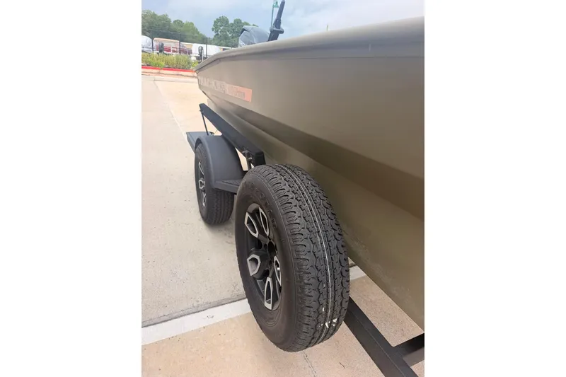Slide: The Image of 2026 Tracker Grizzly 1756 MARSH boat on trailer, showcasing tire and hull details. - 3