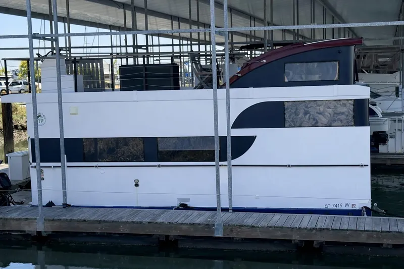 Slide: The Image of Modern 2022 Navisyo NV.08 houseboat docked in a marina under a covered structure. - 1
