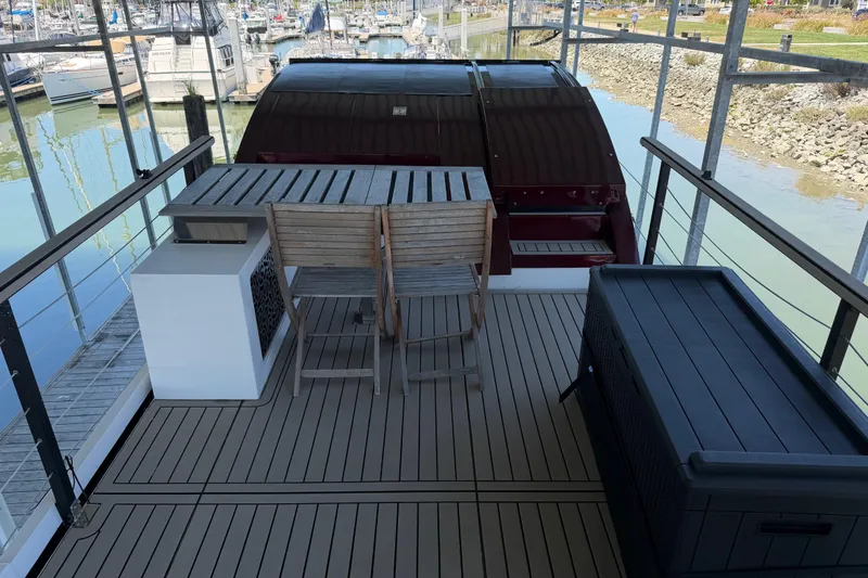 Slide: The Image of Navisyo NV.08 2022 yacht deck with wooden furniture and marina view. - 12
