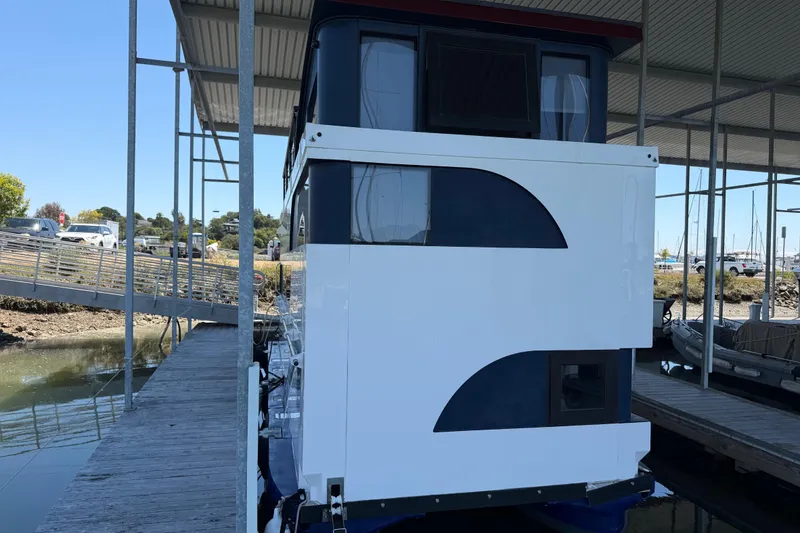 Slide: The Image of 2022 Navisyo NV.08 houseboat docked under a covered marina, showcasing modern design. - 2