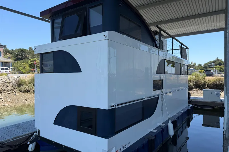 Slide: The Image of Modern 2022 Navisyo NV.08 houseboat docked under a covered marina. - 3