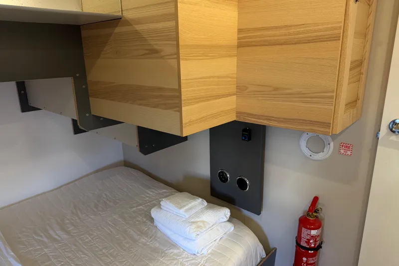 Slide: The Image of Compact cabin interior of 2022 Navisyo NV.08 with bed, wooden cabinets, and fire extinguisher. - 30