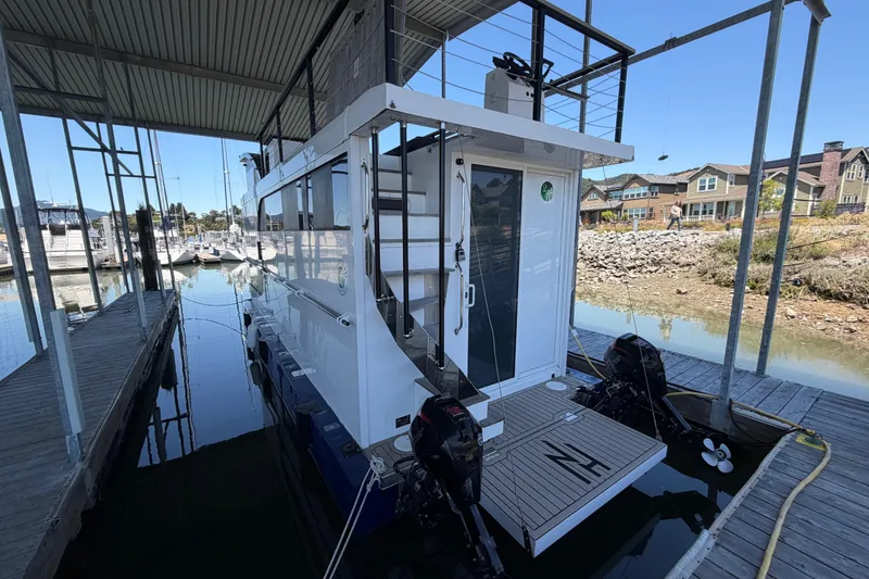 Slide: The Image of Modern 2022 Navisyo NV.08 houseboat docked in a marina, showcasing sleek design and dual outboard motors. - 4