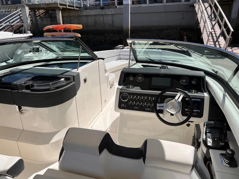 Slide: The Image of Interior of a 2015 Sea Ray SLX 350 boat, helm and seating visible. - 18
