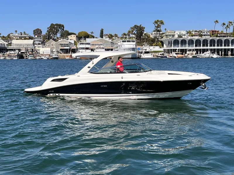 Slide: The Image of 2015 Sea Ray SLX 350 on calm water near coastal buildings. - 2