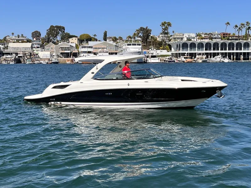 Slide: The Image of 2015 Sea Ray SLX 350 boat on calm water near coastal town. - 3